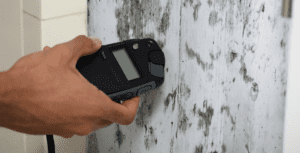closeup of mold remediation specialist testing home walls