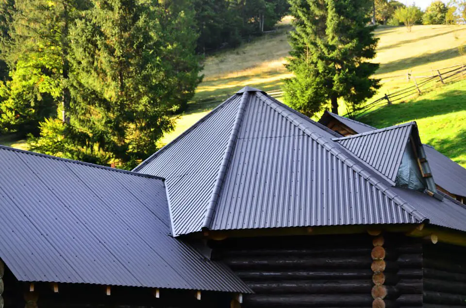 corrugated metal roof-black metal roof on a log house