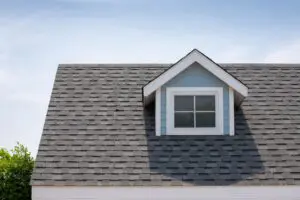 metal roof vs shingles-close up of gray architectural shingles on a blue sided house