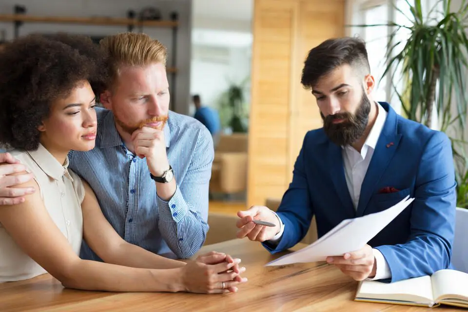 roof insurance claim-a couple talking with an insurance agent and looking over paperwork