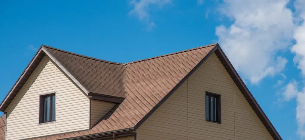 chimney on the roof of the house against the blue sky hip roof vs gable roof