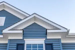 Decorative gable roof with white cornice, blue horizontal vinyl