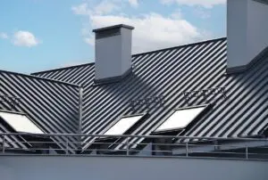 Close-up house retro roof panel with standing seam and fasteners. Classic style black metal panel with rebate joint. Modern galvanized steel roofing sheet with ribs. Falz roofing. Building's covering