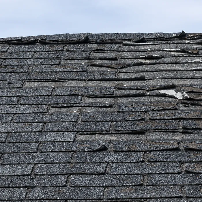 extreme case of curling roof shingles due to storm damage