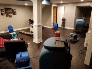 Fans and dehumidifiers in a basement that is drying out after a water leak