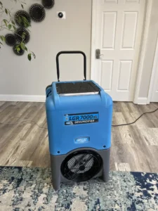 close-up view of a blue humidifier inside a home that has experience water damage
