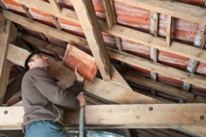 man inspecting leak in attic