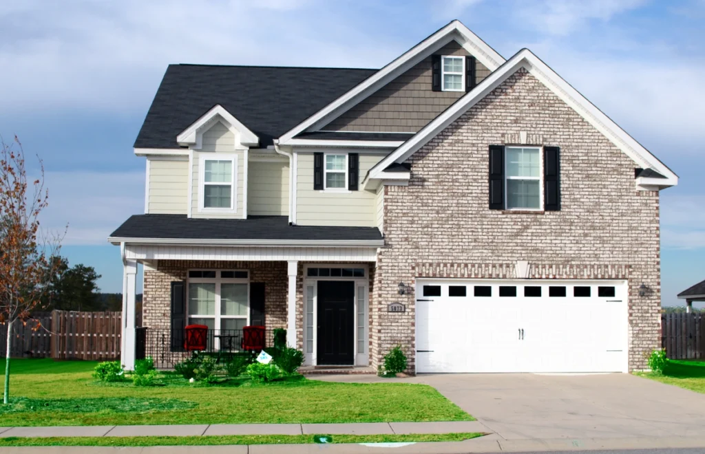 roofing lewis center oh-cream colored home with brick facade and dark shingled roof