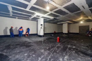 workers waterproofing a basement
