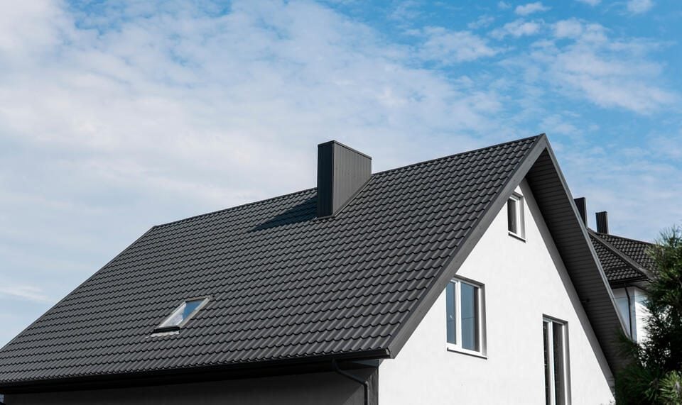 7 Most Popular Metal Roof Colors (2025) - All Phase Roofing & Restoration metal roof colors-black metal shingles on a white house
