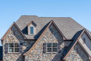 best roof shingles-stone sided house with gray shingled roof