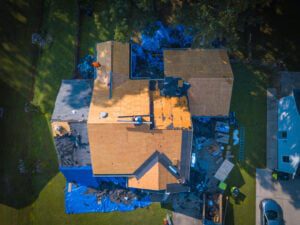 should I stay home during roof replacement-aerial view of debris around house during roof replacement