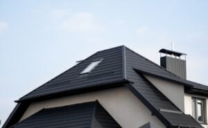 Roofing: New Albany - All Phase Roofing & Restoration Black metal tile roof. Roof metal sheets. Modern types of roofing materials. Roof of the house, metal roof tile against the blue sky. Building