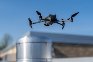 Bexley's Top Trusted Storm Damage Repair Team - All Phase Roofing & Restoration Drone being used to perform an aerial inspecting of HVAC RTU equipment on a commercial roof.