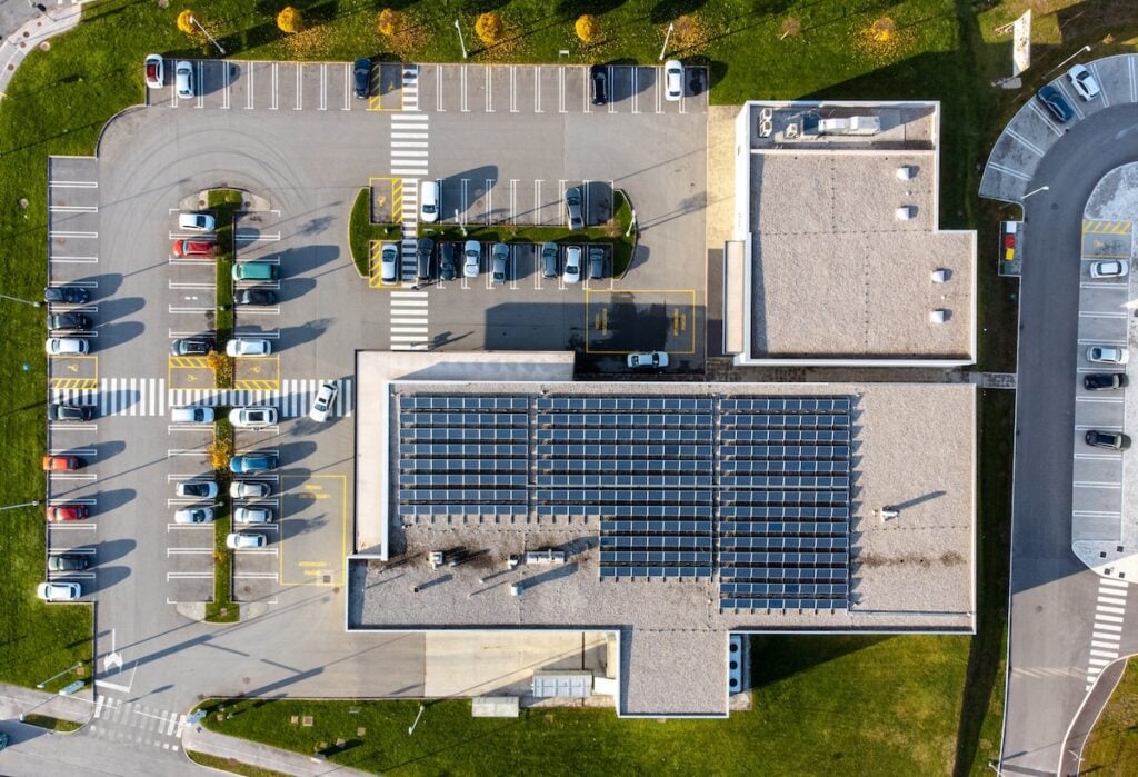 Commercial Roof Cleaning (7 Tips to Extend Lifespan) - All Phase Roofing & Restoration Array of solar panels on the roof of a commercial building top down